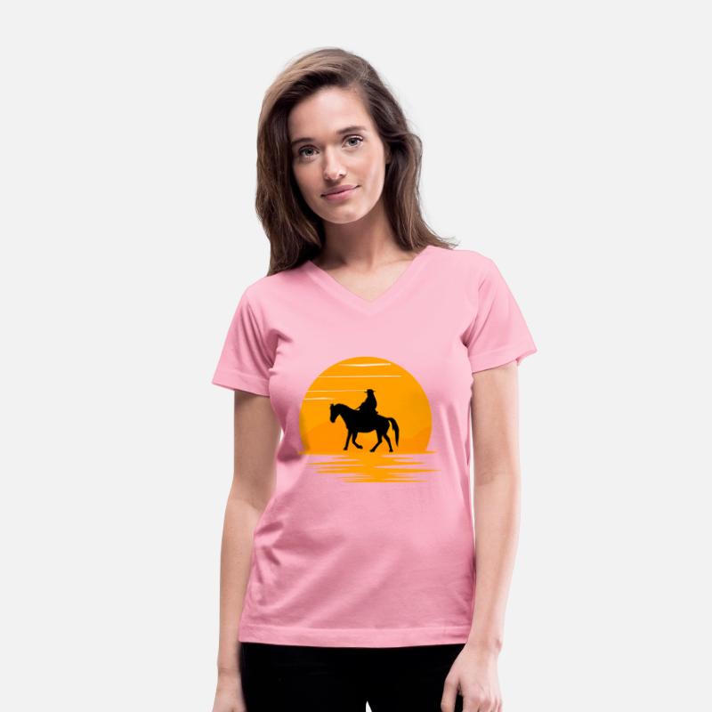 A cowboy walking on his horse in sunset